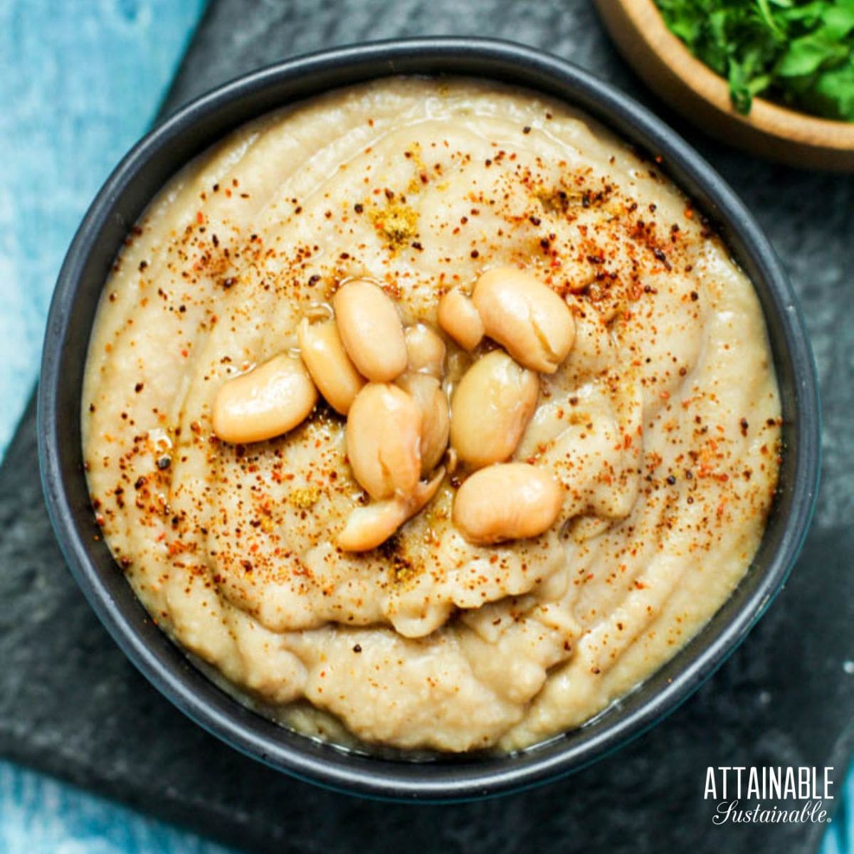 Bowl of refried beans, garnished with a few whole pinto beans.