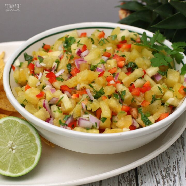 bowl of pineapple salsa with halved lime.
