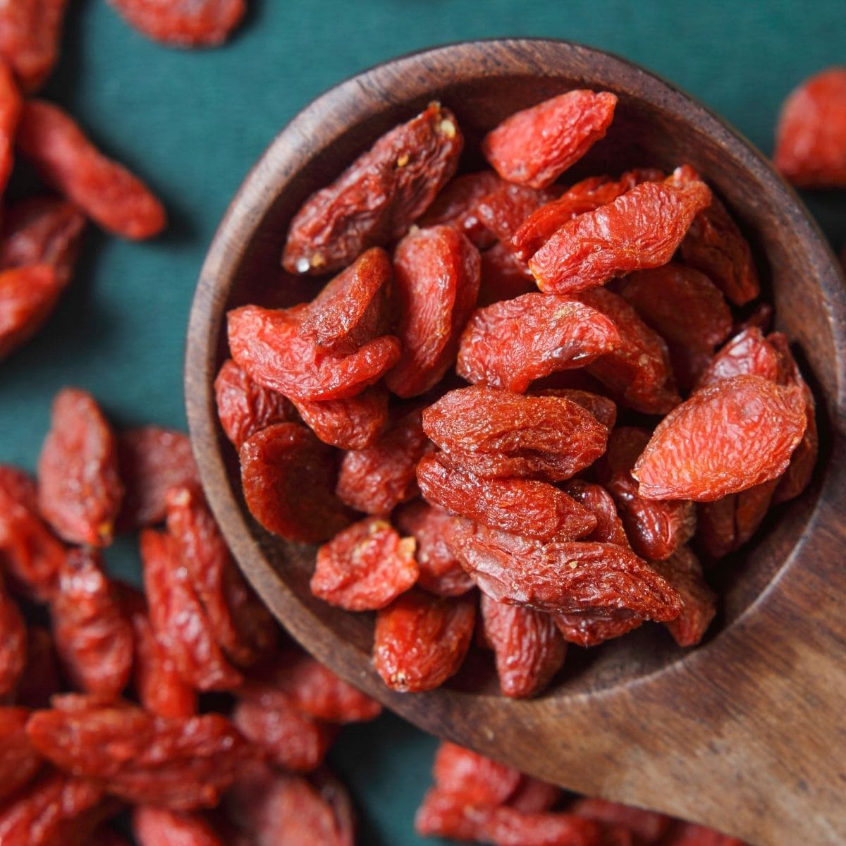 Dried goji berries in a wooden spoon, ready for eating.