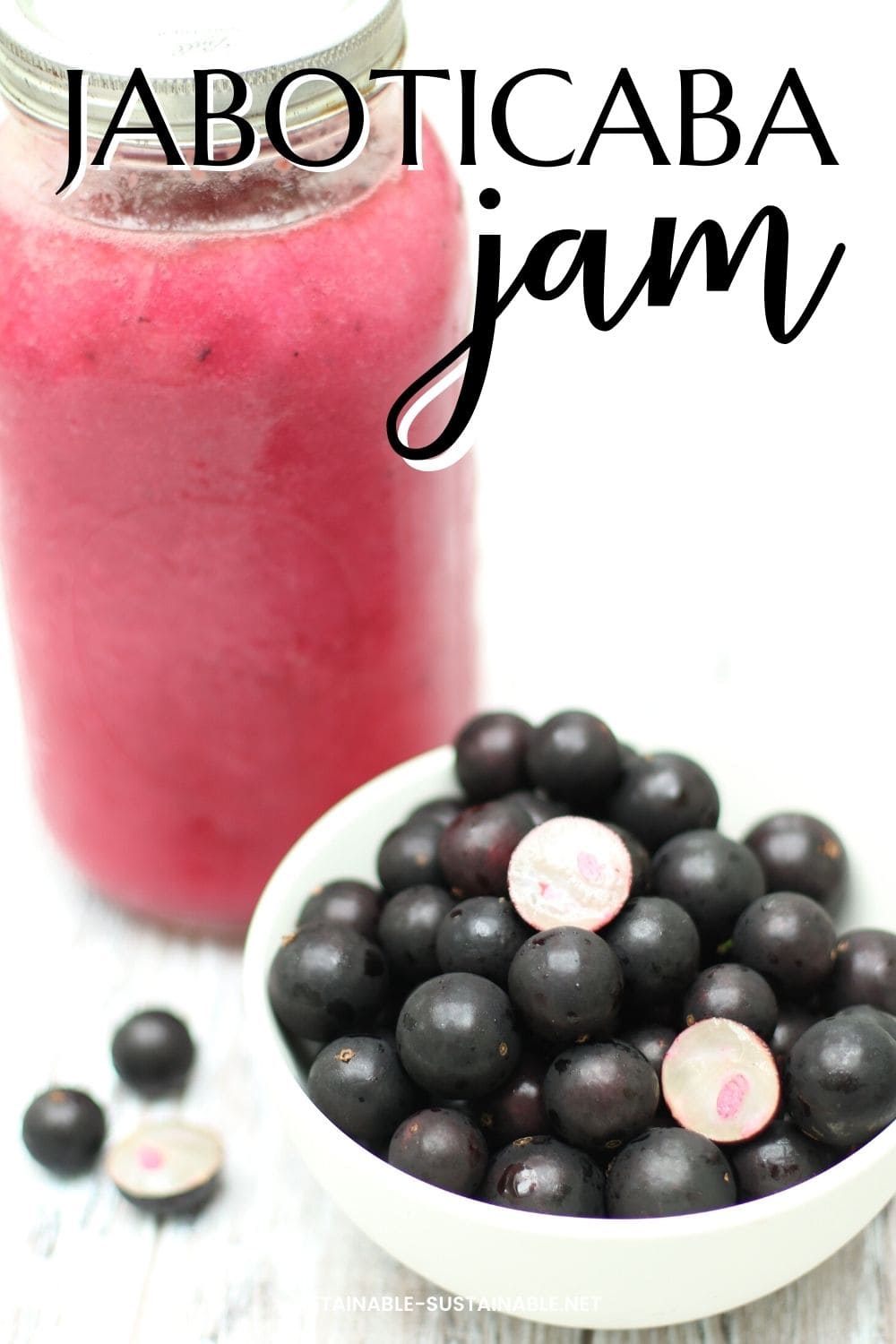 jaboticaba fruit in a bowl with a jar of pink juice.