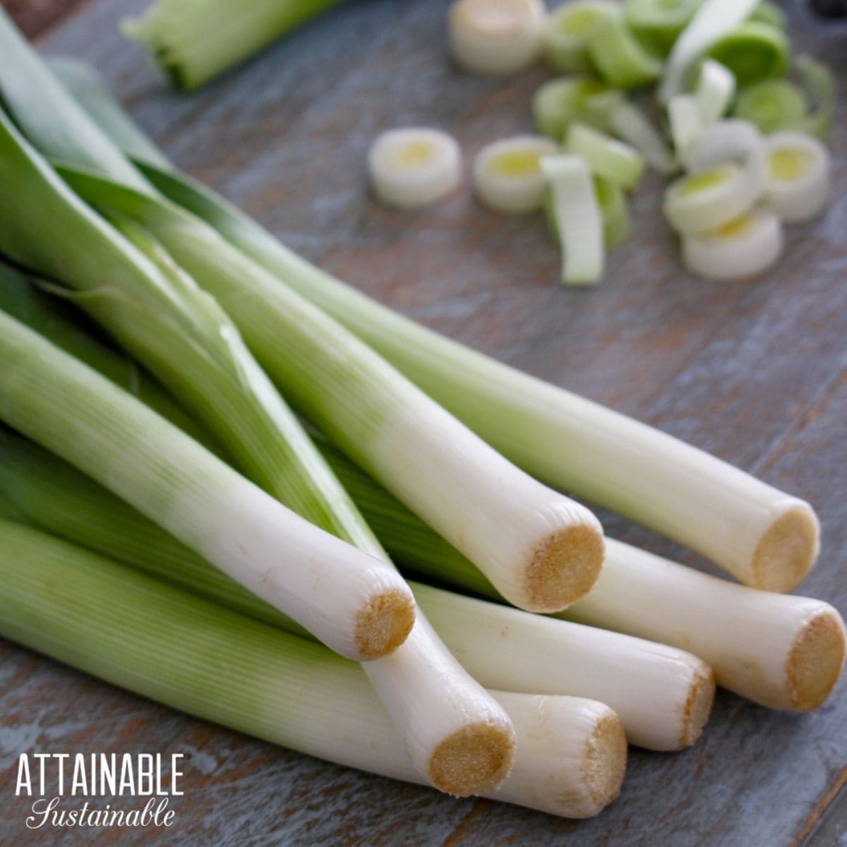 Whole leeks and chopped leeks on a cutting board. 