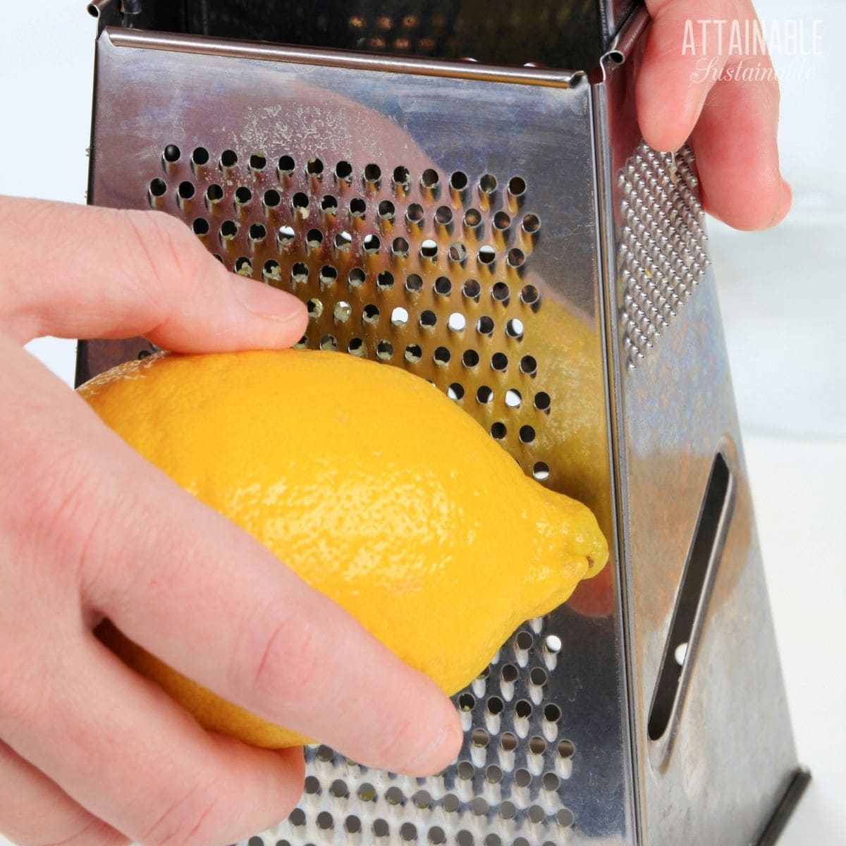 lemon in a hand with a box grater.