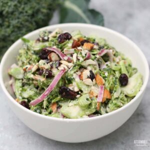 broccoli salad with red onions in a white bowl.