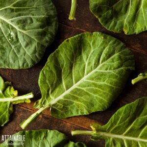 Collard greens on a dark wooden cutting board.