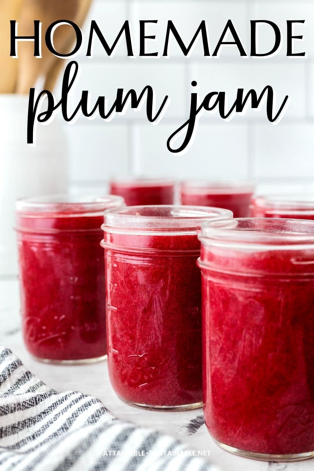 jars of plum jam on a counter, ready for canning lids. 