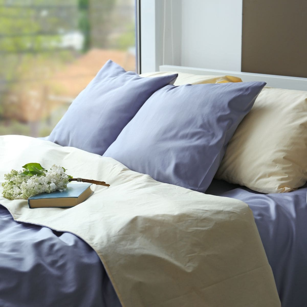 bed made with blue and tan bedding.
