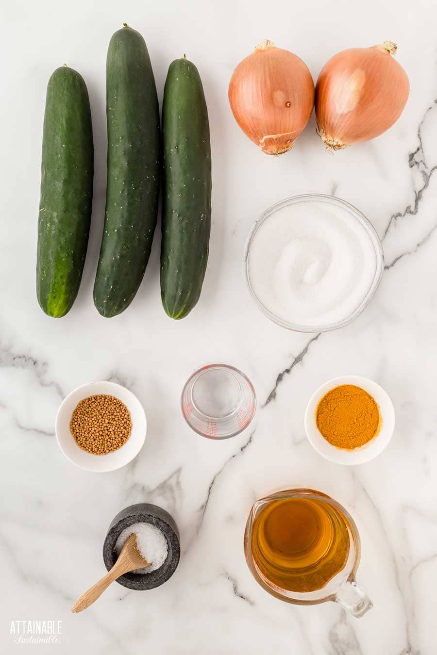 ingredients for bread and butter pickles on a marble background.