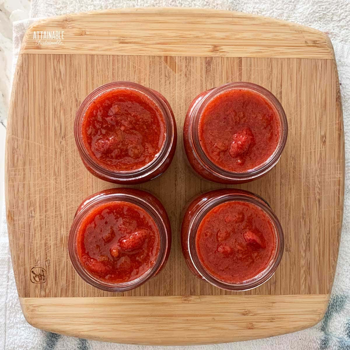 4 jars of pink jam, from above, no lids.