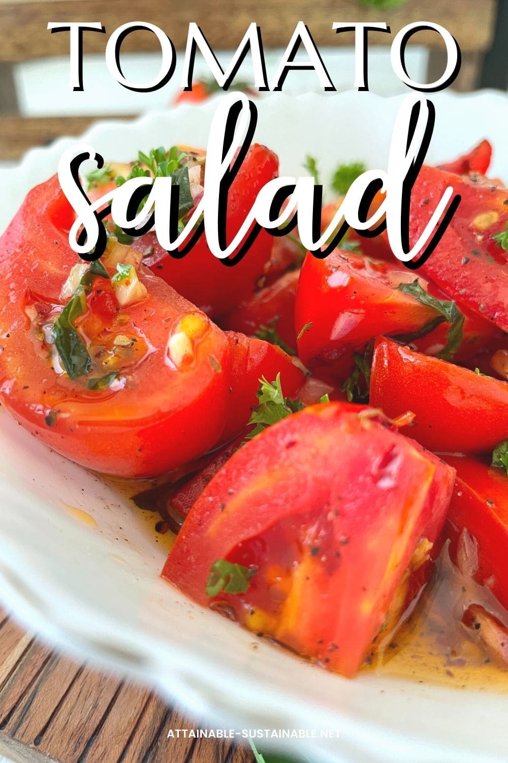 A close up side view of tomato salad in a fancy white bowl with chopped tomatoes, red onions, and fresh parsley. White words on top read tomato salad.