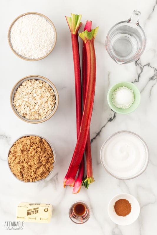ingredients for rhubarb crisp recipe on a marble background.