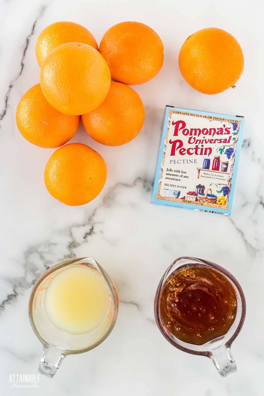 ingredients for making orange jelly on a marble countertop.