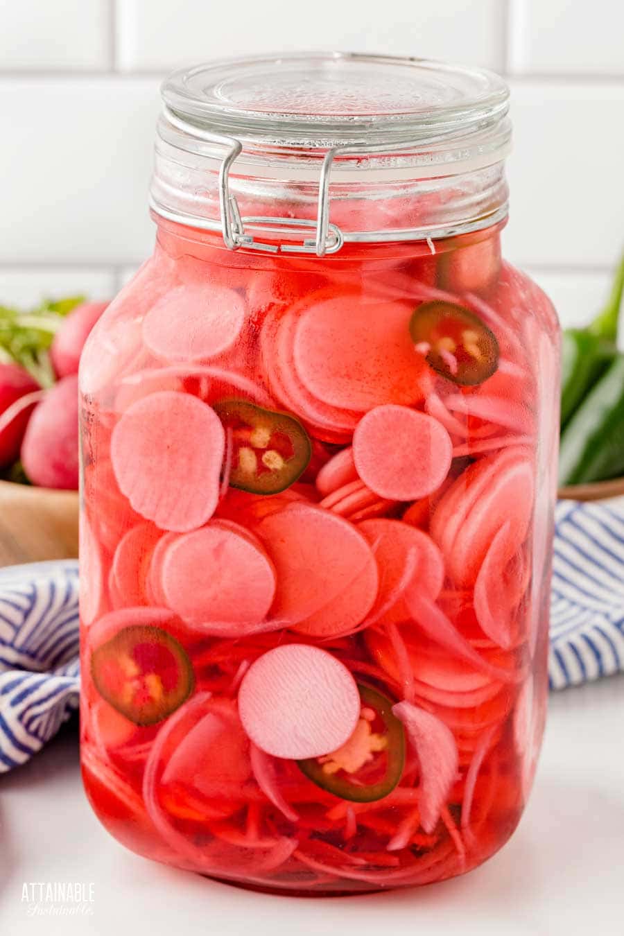 Radishes after pickling; the brine has turned pink.
