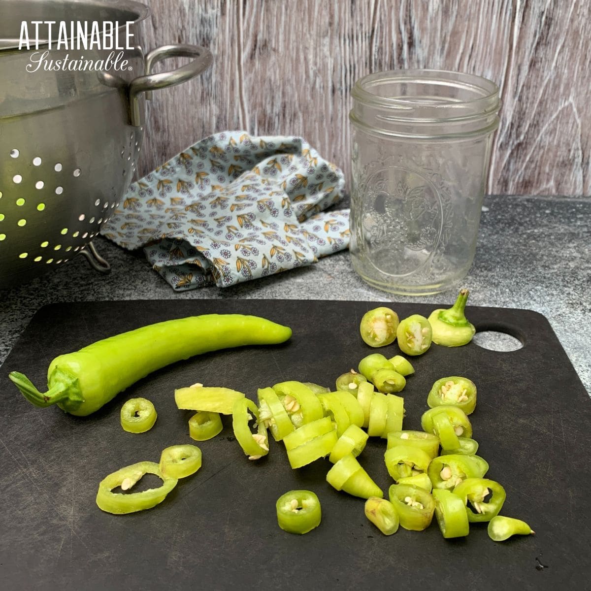 banana peppers in the process of being chopped on a black cutting board.