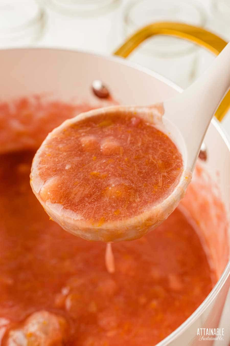 white ladle showing cooked rhubarb.