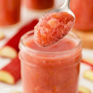 spoonful of rhubarb jam, with jar in background.