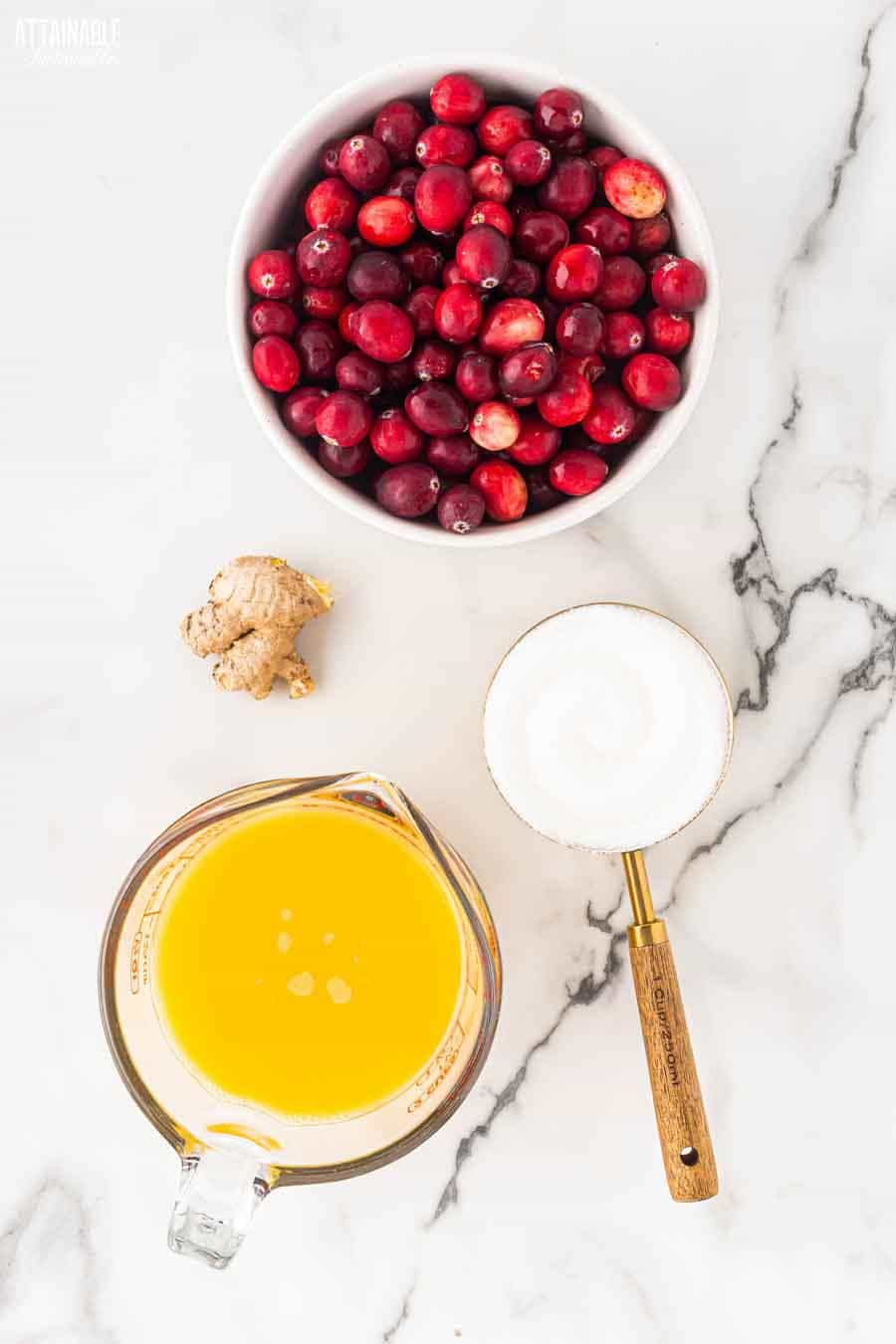 ingredients for making cranberry sauce on a marble background.