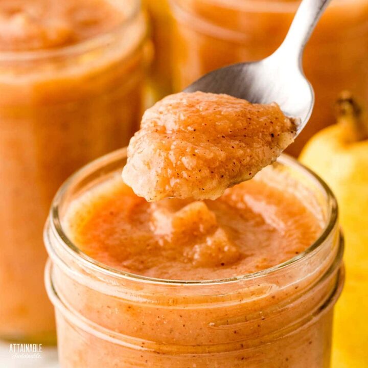 jar of pear butter with a spoonful hovering above.