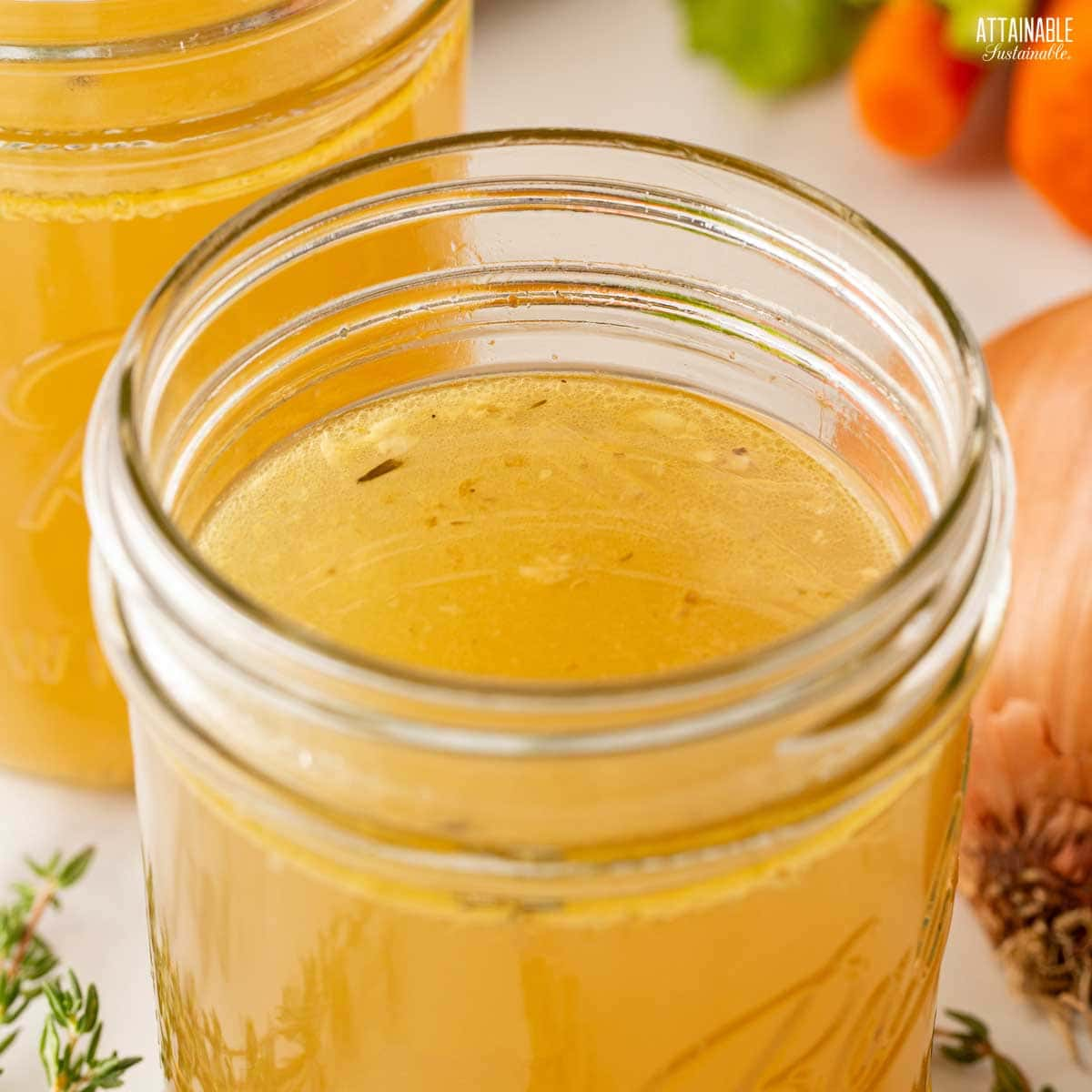 glass jar of canning broth, showing a suitable headspace for freezing.