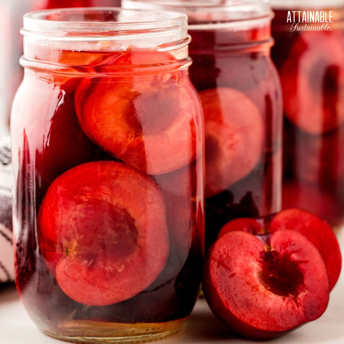 purple plum halves in jars with liquid. 