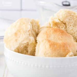 white bowl of lightly browned dinner rolls.