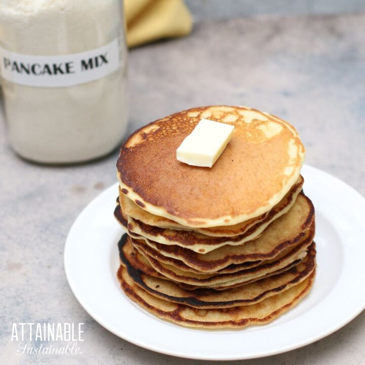 stack of pancakes with jar of pancake mix behind.