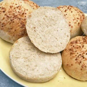 yellow plate of potato buns, one sliced open showing the white fluffy center.