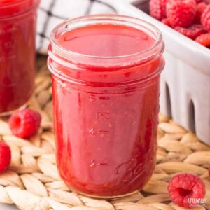 bright reddish pink raspberry puree in a glass canning jar.