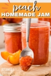 2 jars of peach jam, one opened, with a spoon full of jam leaning against it.