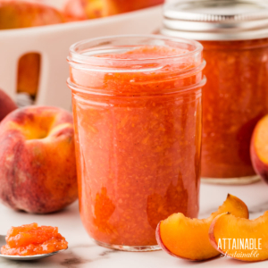 Half pint canning jar full of peach jam, lid off.