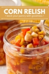 close up of corn relish in jar, with a spoon taking some out.